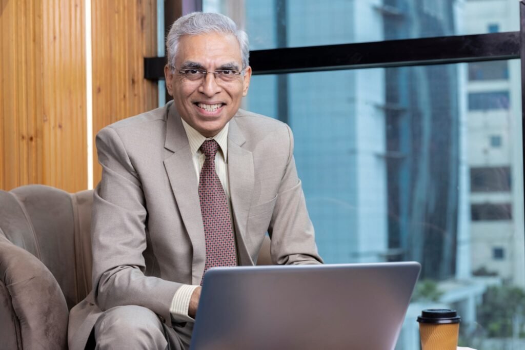 indian businessman sitting on sofa and working on laptop at modern office